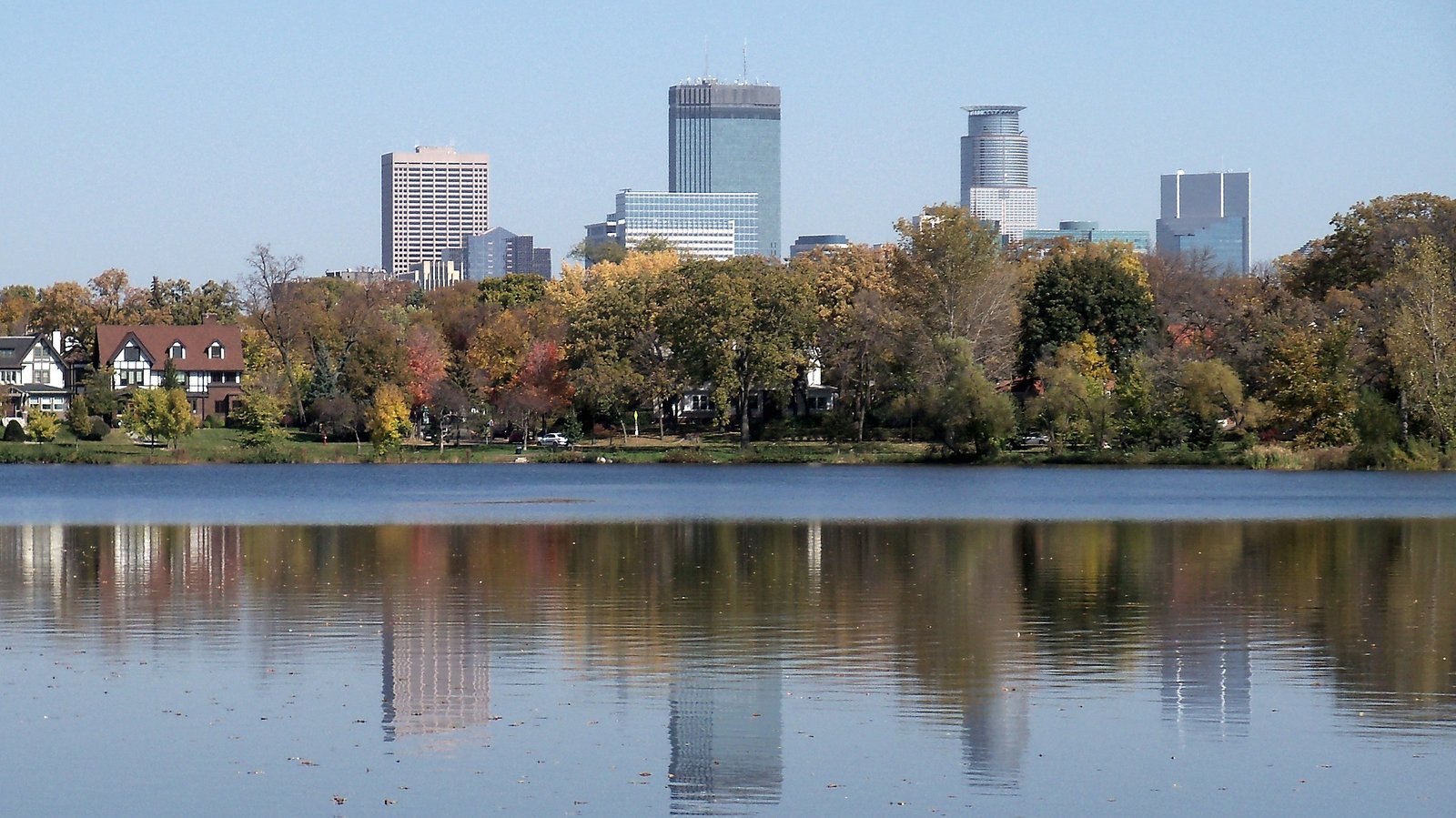 Minneapolis skyline reflected near water representing the Metro Minnesota lake region.