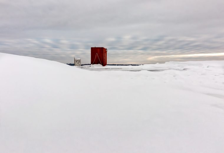 Snow and ice fishing houses on a Minnesota lake used for winter caution planning.